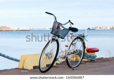 Bicycle with flat tire standing at the pier of Oskarshamn, Sweden, beside a bollard.