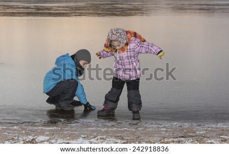 Two children, a girl and a boy, on the ice of a frozen lake in Sweden