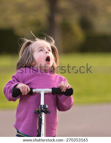 Cute little girl with a scooter shows indignant expression, very strong facial expressions, enjoy!