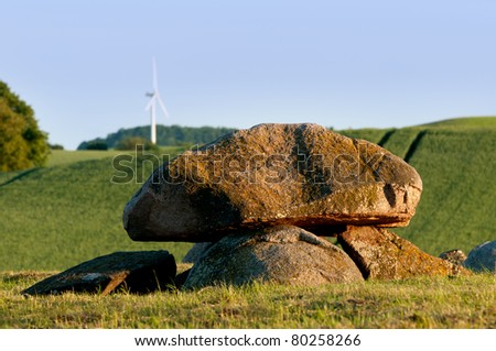 ancient stone tomb and modern wind turbine
