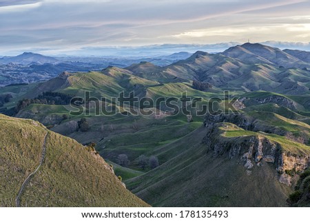 Beautiful and grand rolling hills during sunset.  The land is used as pasture for sheep.