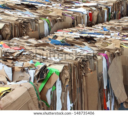 Recycling cardboard packaging concept with stacks of compressed corrugated paper garbage as a symbol to recycle for conservation and the environmental technology business.