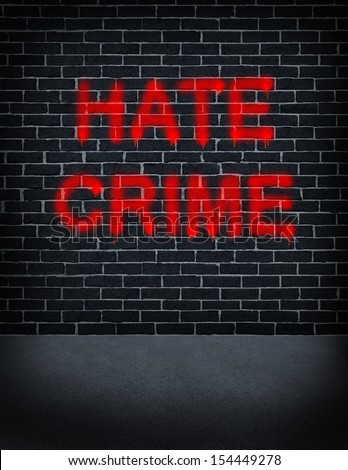 Hate crime social problem concept with a dark grey brick wall with graffiti spray painted as a symbol of racism and race discrimination as an illegal act of hatred and vandalism based on xenophobia.