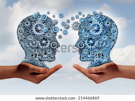 Business technology concept as two hands holding a group of  machine gears shaped as a human head as a symbol and metaphor for the transfer of industry information or corporate training.