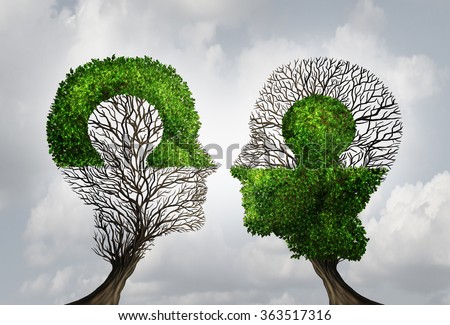 Perfect business partnership as a connecting puzzle shaped as two trees in the form of human heads connecting together as a corporate success metaphor for cooperation and agreement as equal partners.