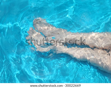 Legs of a child with blue water motion blur background