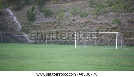 Soccer field with net and goal set up on the grass background