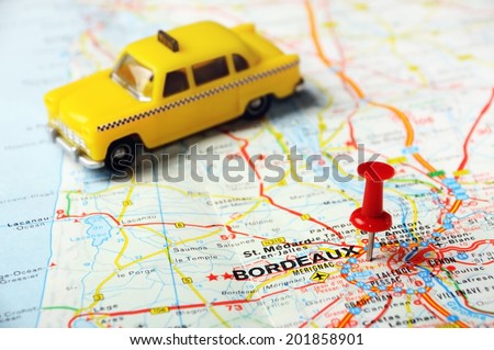 Red push pin pointing at Bordeaux , France  map   and a taxi