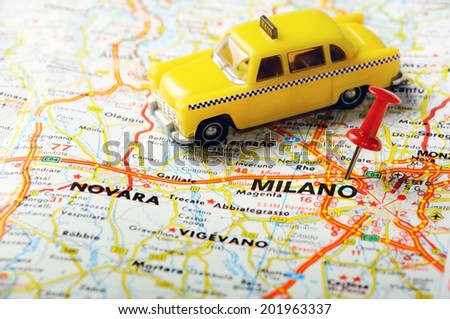 Red push pin pointing at Milano, Italy  map   and a taxi