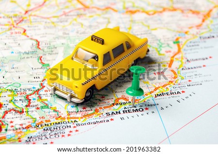 Green  push pin pointing at San Remo ,Italy  map   and a taxi