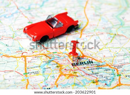 Close up of Berlin map with red pin an a cabrio - Travel concept