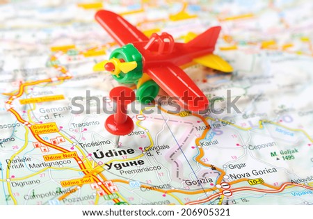 Close up of  Udine  , Italy map with red pin and airplane  - Travel concept