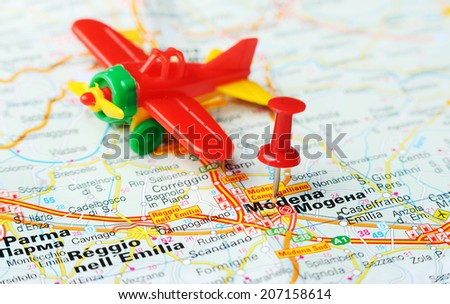 Close up of  Modena , Italy map with red pin and airplanei   - Travel concept