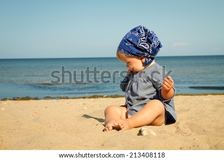 little girl by the sea. child he played in the sand. one year