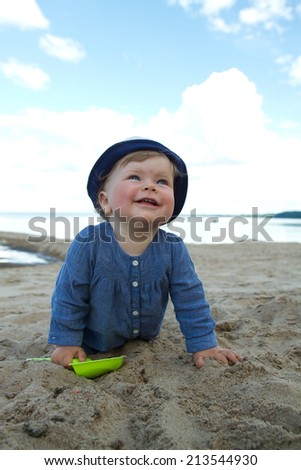 little girl by the sea. child he played in the sand. one year