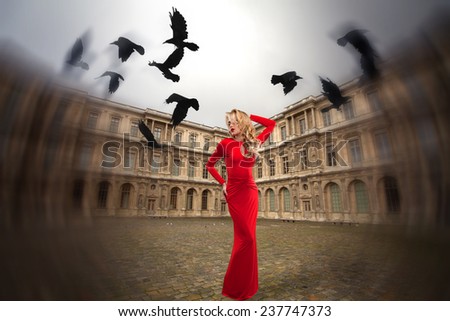 stylish girl stands in the center of Paris, near the Eiffel Tower. soars in the sky a flock of crows.