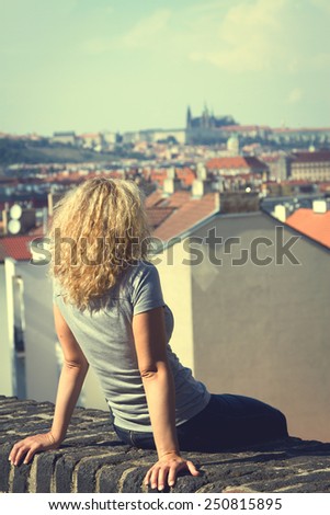 girl sitting on the roof of a house in Prague. top view of the city. top view . lifestyle