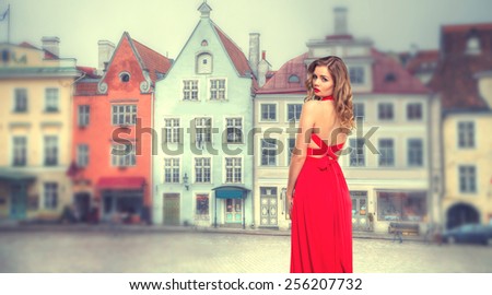 girl in red dress in the old quarter of the European city of Tallinn. Vintage photos in retro style