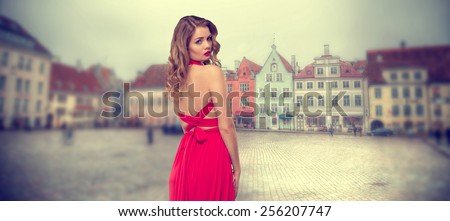 girl in red dress in the old quarter of the European city of Tallinn. Vintage photos in retro style