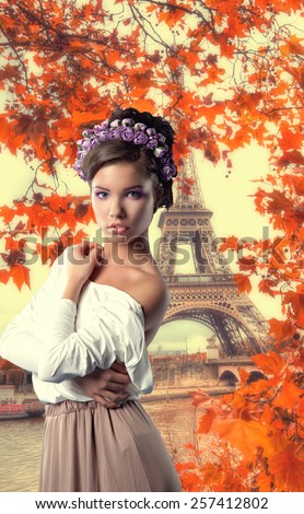 sexy young brunette girl with a wreath on his head stands on the banks of the Seine in Paris on a background of the Eiffel Tower. Vintage photos in retro style