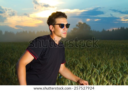 lifestyle. a man in a field at sunset enjoying life, good weather, fresh air and silence