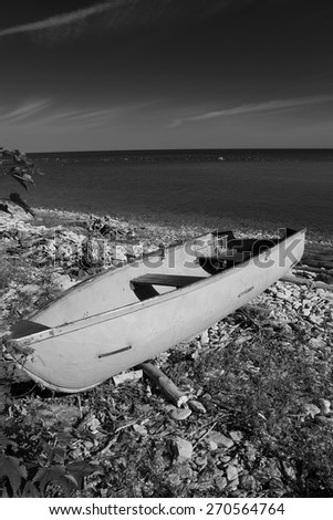 black and white photography. sea and the horizon and the sand and the rocks and the stairs and the boat