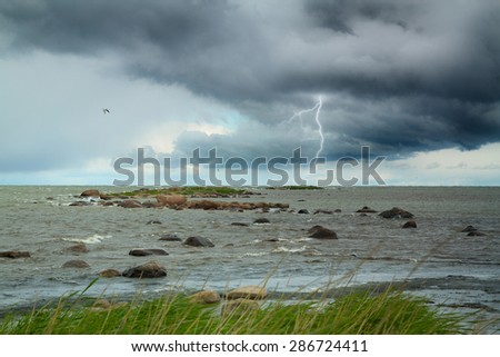 Lightning at sea. summer storm coming ashore. the waves beating against the rocks