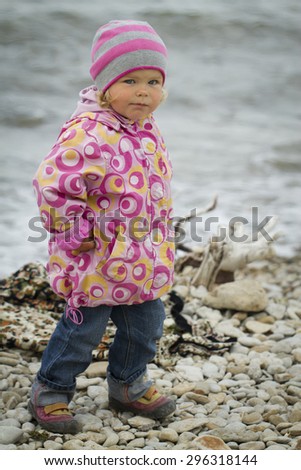 Girl in the autumn at the sea . walking on rocks in the ocean background