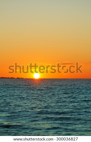 sunset on the sea. red and orange sun and blue water