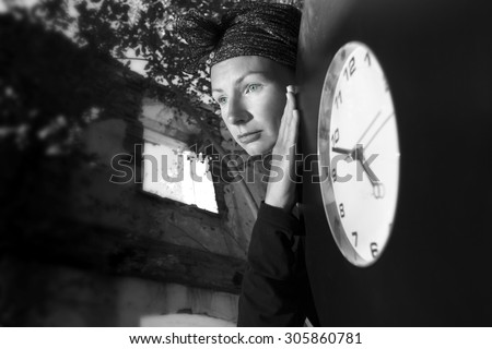 Girl on the ruins of the house with a huge clock in his hands. The symbolism of the time, the transience of life.