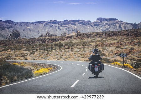couple on a motorcycle traveling in the mountains