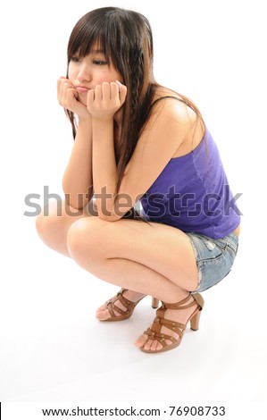 stock photo Pretty girl squatting over white background