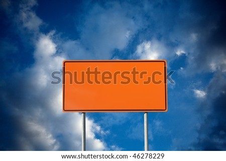 Blank orange construction sign against cloudy sky