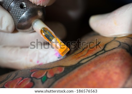 The close-up of a tattooing needle during the tattoo