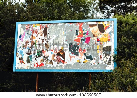 big advertising billboard with old torn posters