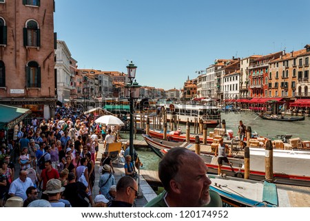 ITALY, VENICE - JULY 16: Crowd of tourist near Grand Canal on July 16, 2012 in Venice. More than 20 million tourists come to Venice annually.