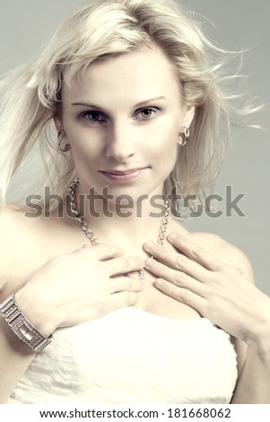 studio portrait of beautiful woman with white dress and waving hair
