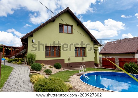 repaired rural house, fixed facade, insulation and painted to green  color witg swimming pool