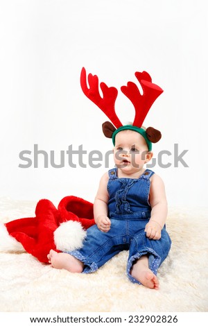 Child girl with Christmas santa hat and reindeer antlers on white background