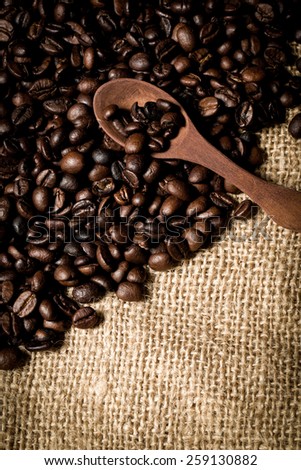 pile of fresh and bio aromatic coffee beans and wooden spoon with space for text
