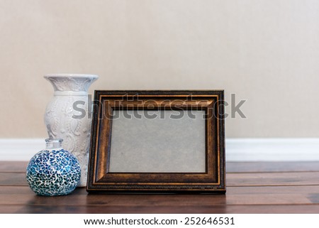 Empty frame on the shelf with objects around it for displaying photography and or art