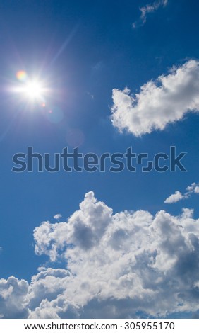 star-shaped sun in blue sky with light clouds