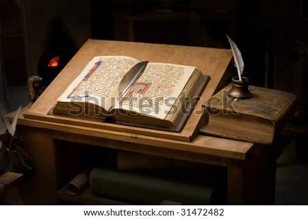 Old book and inkpot in a library table.