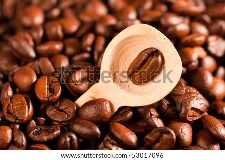 coffee beans in a spoon, on the background of coffee (selective focus)