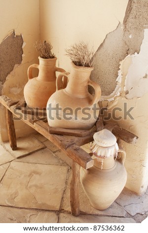 Pitchers on shelf against the background of the old wall