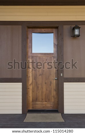 Dark wood front door of a home. View of a rustic, dark wood stained front door. Vertical shot.