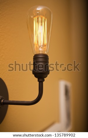 Close up shot of a light bulb/vertical shot of a vintage illuminated light bulb in a home
