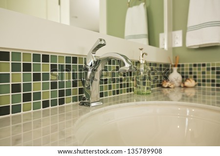 Bathroom Sink Of An Upscale Home/Horizontal Shot Of An Elegant, Polished And Clean Sink In An Upscale Home With Colorful Green Tiling