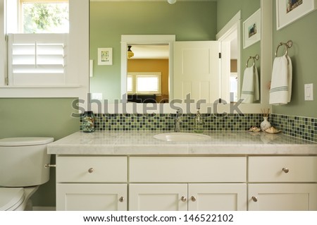 Bathroom Vanity & Mirror/Horizontal shot of a custom master bathroom vanity with double sink, tiled counter top, and window view.