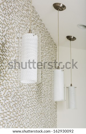 An arrangement of unlit light fixtures in a home bathroom hanging from the ceiling.